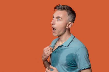 Sad man suffering from heavy sweatingの写真素材