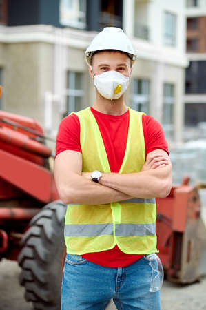 Worker in a safety vest standing by a built structureの写真素材