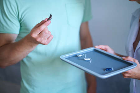 Male hand showing best hearing aidの写真素材