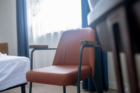 Chair near bed in small roomの写真素材