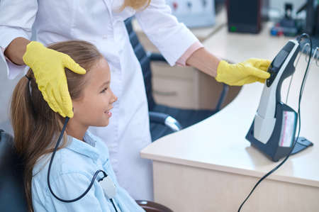 Pleased girl having her hearing checked on the audiometerの写真素材