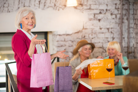 Cheerful senior females with shopping bags looking happyの写真素材