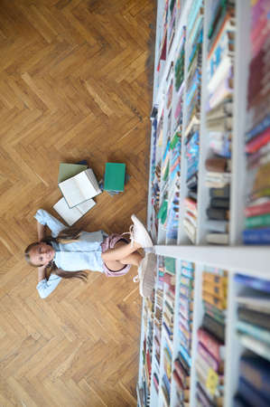 Pretty Caucasian pupil taking a break from reading booksの写真素材