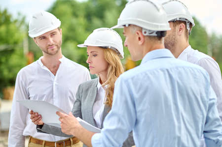 Serious female inspector focused on checking building documentationの写真素材