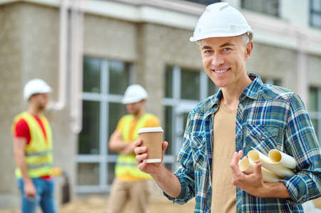 Joyous engineer posing for the camera during the coffee breakの写真素材