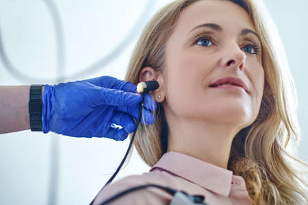 Tranquil patient undergoing an audiometry test performed by an audiologistの写真素材