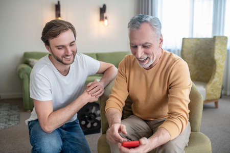 Young man explaining his dad how to use a new smartphoneの写真素材