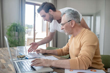Two men working together on a project and looking interested