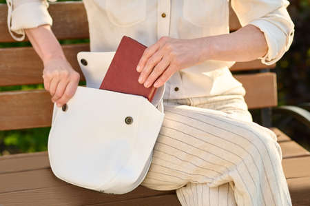 Female hands putting notebook in open bagの写真素材