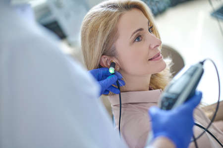 Beautiful adult woman at reception at otolaryngologist