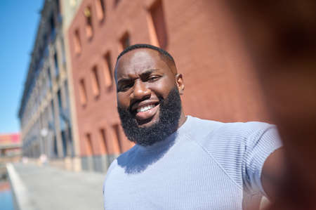 A close up picture of dark-skinned bearded man