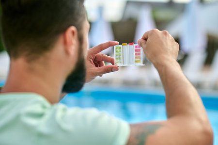 A man holding lacmus paper after water testingの写真素材