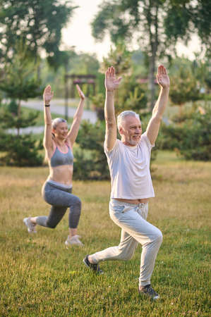Two sportive mature adults exercising in the parkの写真素材