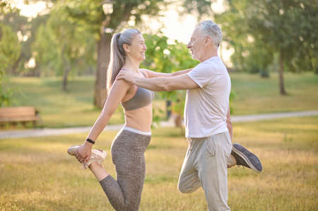 Two sportive mature adults exercising in the park