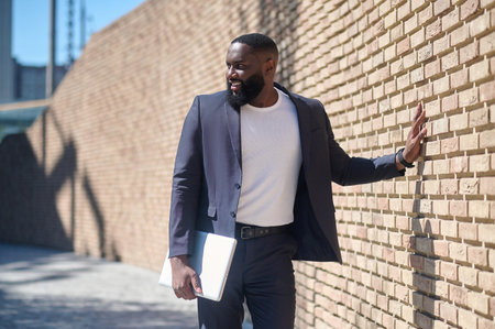 An african american man in a suit standing near the brick wallの写真素材