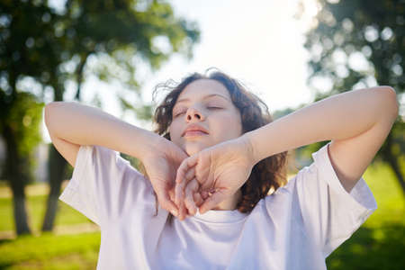 A ginger curly-haired girl looking relaxed and tranquil
