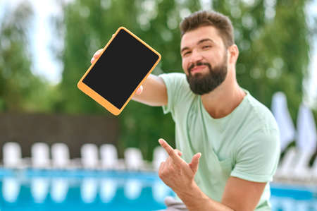 A bearded young man with a tablet in handsの写真素材