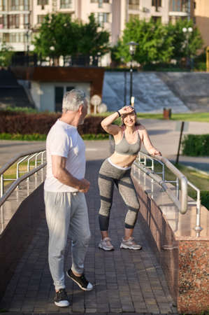 A man and a woman having a stop while morning joggingの写真素材