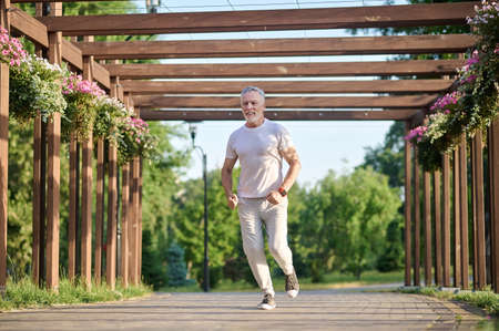 A man in sporstwear jogging in the parkの写真素材