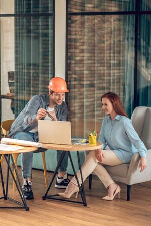 Man showing laptop screen to smiling womanの写真素材