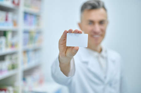 Card in hand of smiling manの写真素材