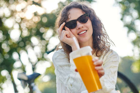 A picture of a girl in sunglasses and a bottle of water in handの写真素材