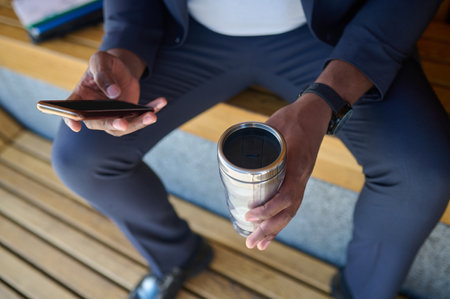 Picture of a man with a phone and a bottle of water in hands