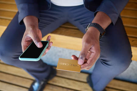 Close up picture of a man holding a credit card and a smartphoneの写真素材