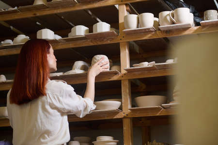 A cute young female potter in her workshopの写真素材