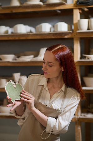 A young long-haired female potter in her workshopの写真素材