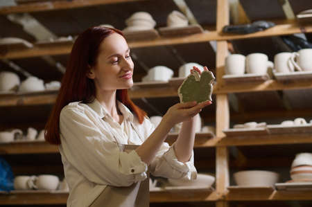 A young long-haired female potter in her workshopの写真素材