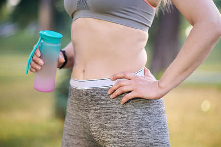 A woman in a sportswear with a bottle in handsの写真素材
