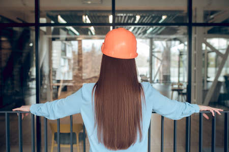 Woman in safety helmet evaluating work doneの写真素材