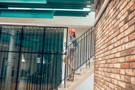 Smiling woman walking down stairs with laptop