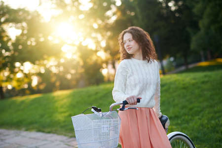 Young girl with a bike in a park in the morningの写真素材