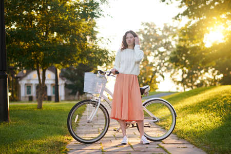Young girl with a bike in a park in the morning