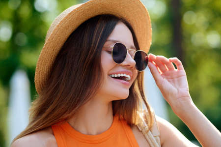A young woman in an orange top near the swimming pool