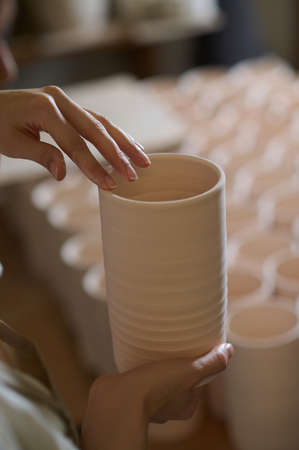 Hands of a potter with a new crockeryの写真素材