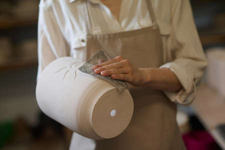 Female potter holding newlymade pots in handsの写真素材