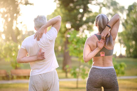 A man and a woman exercising in the parkの写真素材