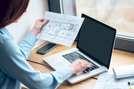 Woman with drawing working on laptopの写真素材