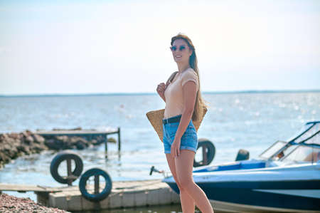 A woman in shorts standing on the beach and feeling wonderfulの写真素材