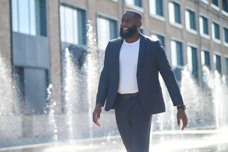 A tall dark-skinned man in a suit in the streetの写真素材