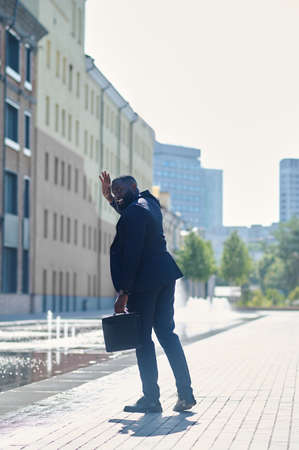 A tall dark-skinned man in a suit in the streetの写真素材