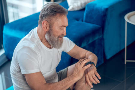 A mature man looking at the watch controlling his pulse after the workoutの写真素材