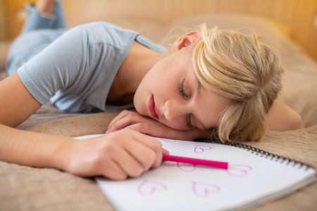 A cute blonde girl napping and looking peaceful