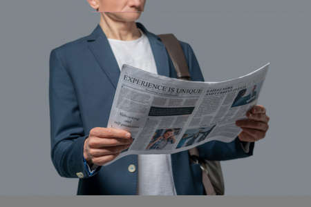 Man with newspaper in hands reading newsの写真素材