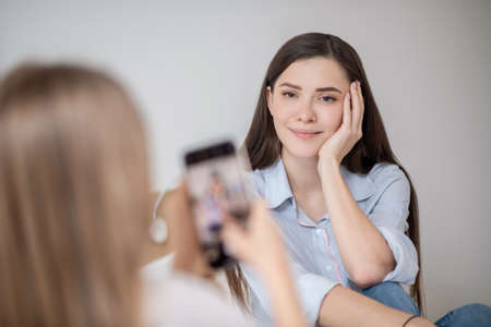 A girl making photo of her pretty motherの写真素材