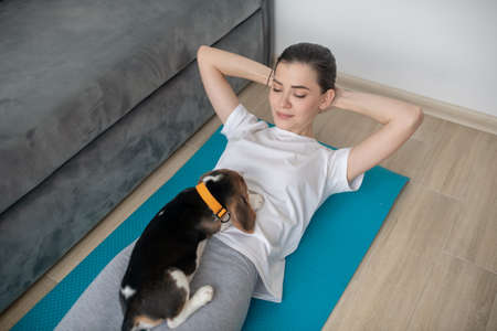 A young woman having a workout with her puppy