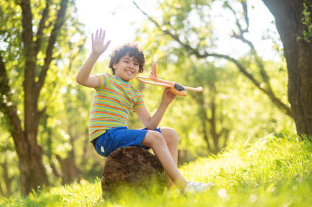 Smiling boy with toy airplane in parkの写真素材